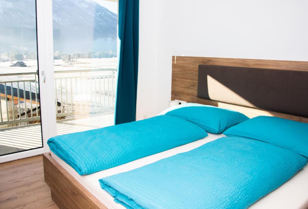 纳瑟莱特Landhaus Juleiko的带阳台的客房内一张带蓝色枕头的床
