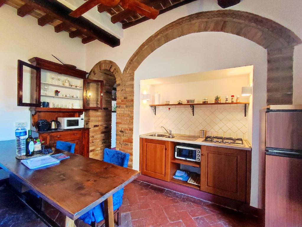圣吉米纳诺Convento San Gimignano Apartments的厨房配有木桌和台面