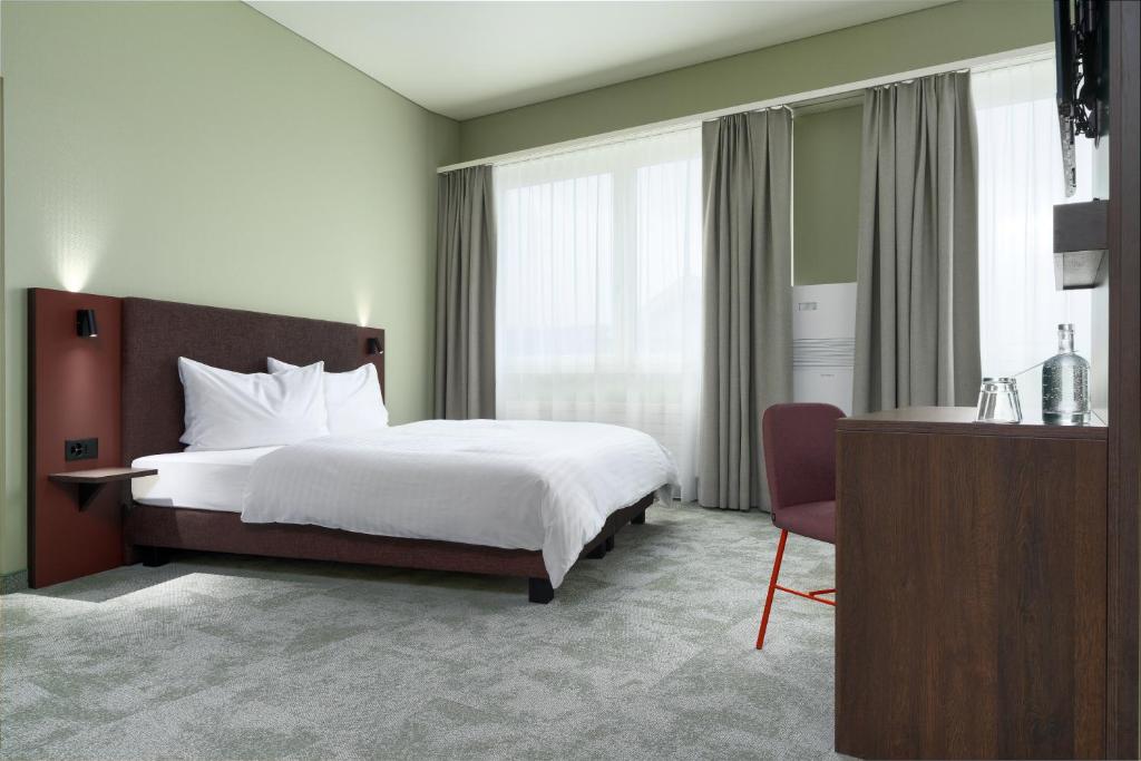 阿劳b-smart hotel Schönenwerd的配有一张床和一把椅子的酒店客房
