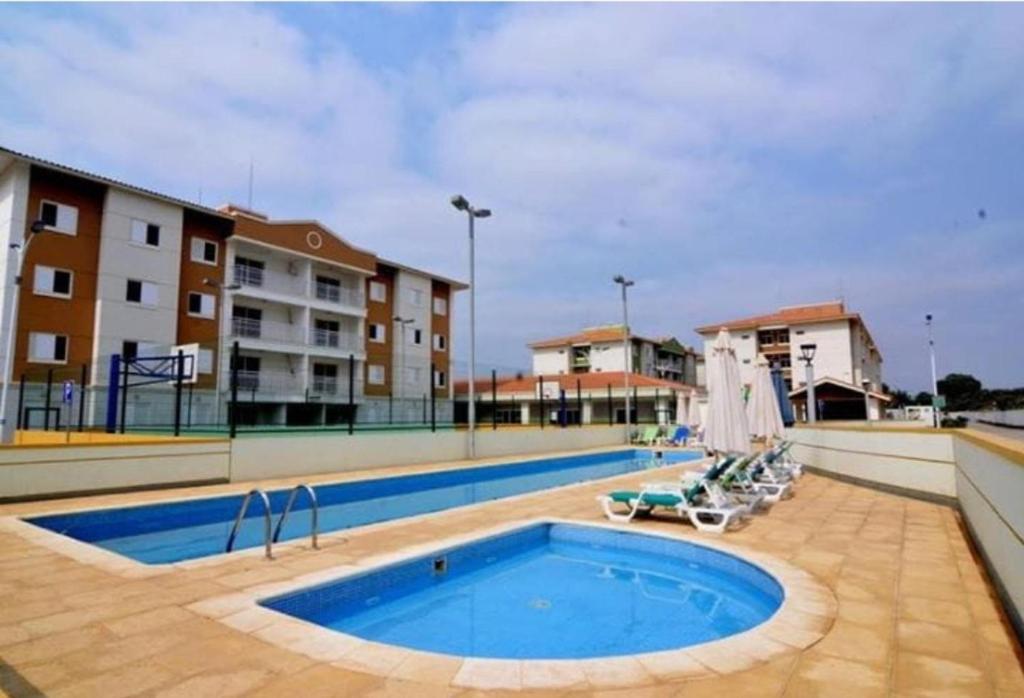 VianaRemarkable 3-Bed Apartment in Viana的一座带椅子的大型游泳池和一座建筑