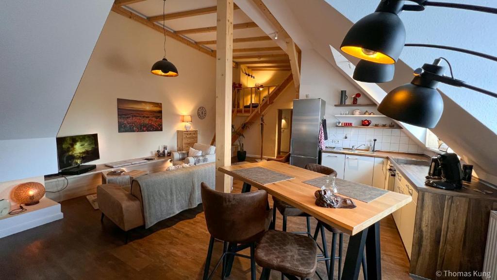 科特布斯Kungs Ferienwohnung的厨房以及带桌椅的起居室。