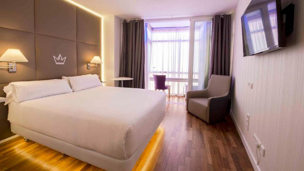马德里艾拉森酒店的酒店客房设有一张白色大床和椅子