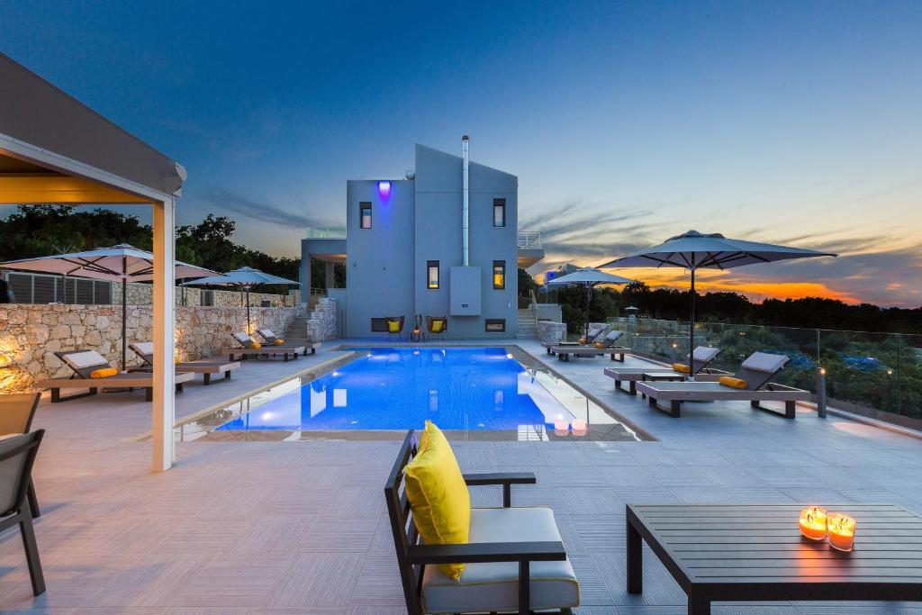 GállosLuxury Cretan Villas with private pools的一座带桌椅的游泳池以及一座建筑