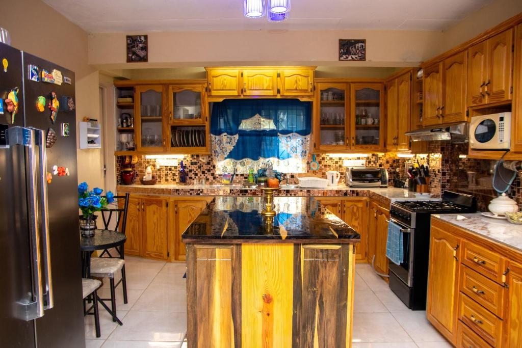 Arnos ValePRI Guest House的一个带木制橱柜的厨房和一个岛上