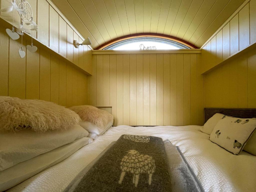 凯珀尔克里格5 Star Shepherds Hut in Betws y Coed with Mountain View的一间带两张床的卧室,位于带窗户的房间内