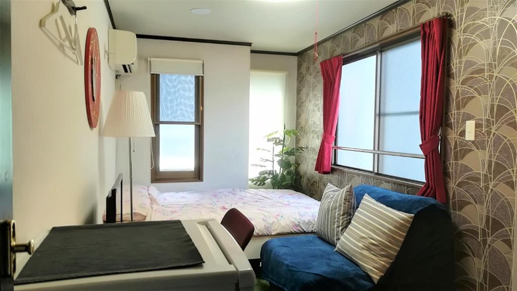 大阪Cote House的一间卧室配有一张床、一张沙发和一个窗口
