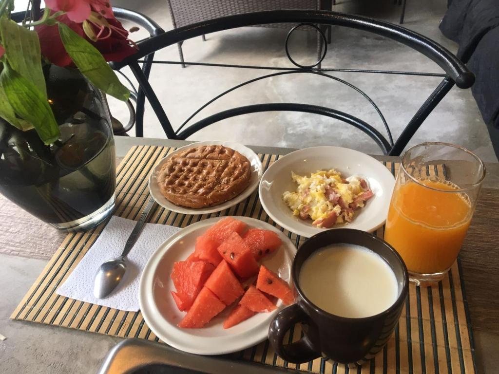 Hogar de Adriane Bed and breakfast cerca al aeropuerto的餐桌,包括麦片牛奶和水果