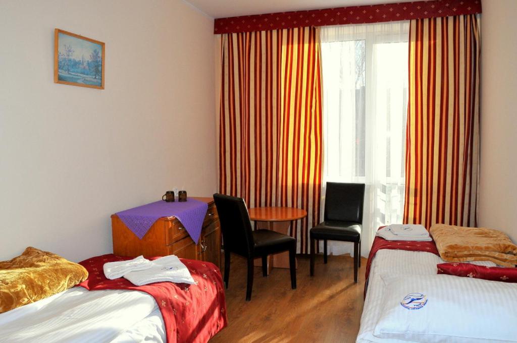 索波特OSW BALTIC Sopot的客房设有两张床、一张桌子和一扇窗户。