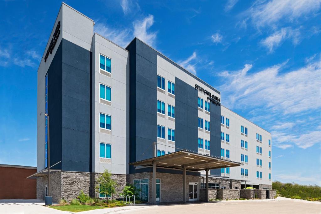 奥斯汀SpringHill Suites by Marriott Austin North的蓝色天空的酒店建筑