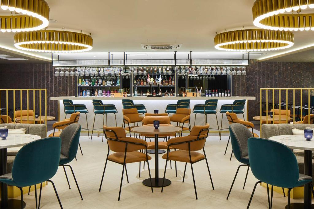 海斯Courtyard by Marriott London Heathrow Airport的一间带桌椅的餐厅和一间酒吧