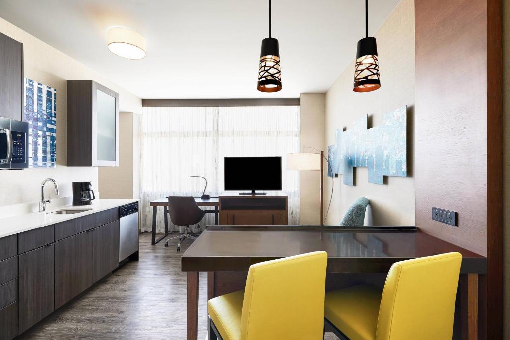 达拉斯达拉斯市中心万豪酒店的厨房配有餐桌和黄色椅子