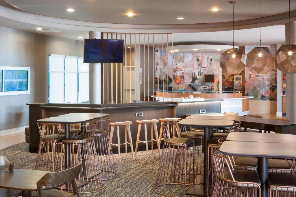 盐湖城万豪盐湖城机场春季山丘套房酒店的一间带桌椅的餐厅和一间酒吧