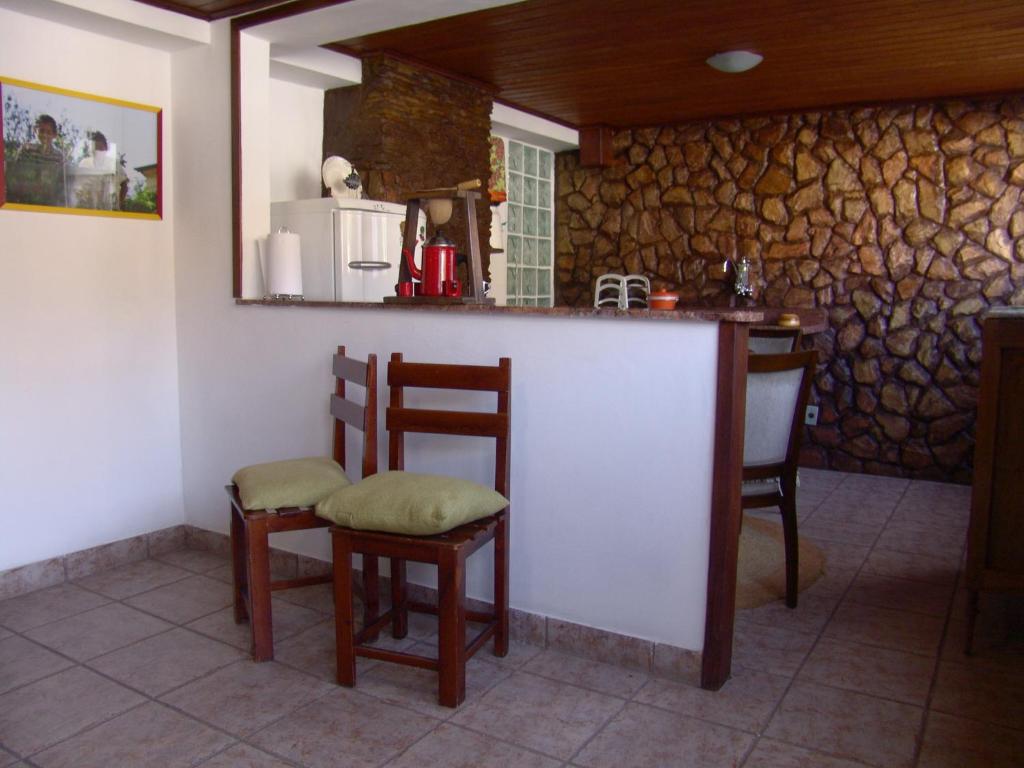 欧鲁普雷图Casa de João的厨房配有带椅子和柜台的酒吧