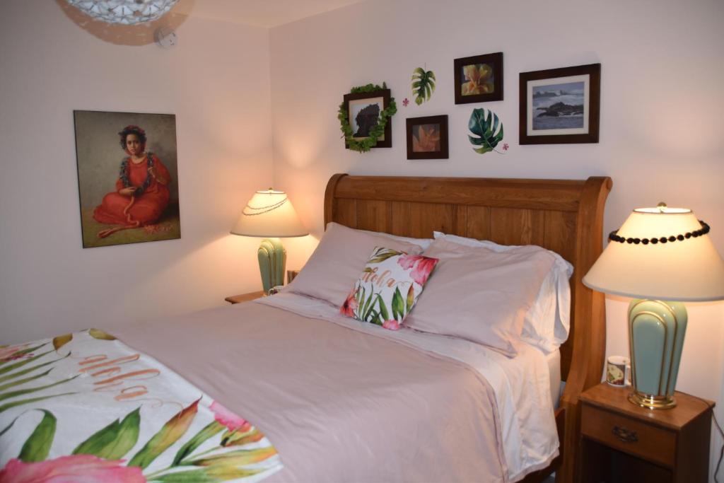 皮克图Seabank House Bed and Breakfast Aloha的一间卧室配有一张带两盏灯的床,墙上挂有图片