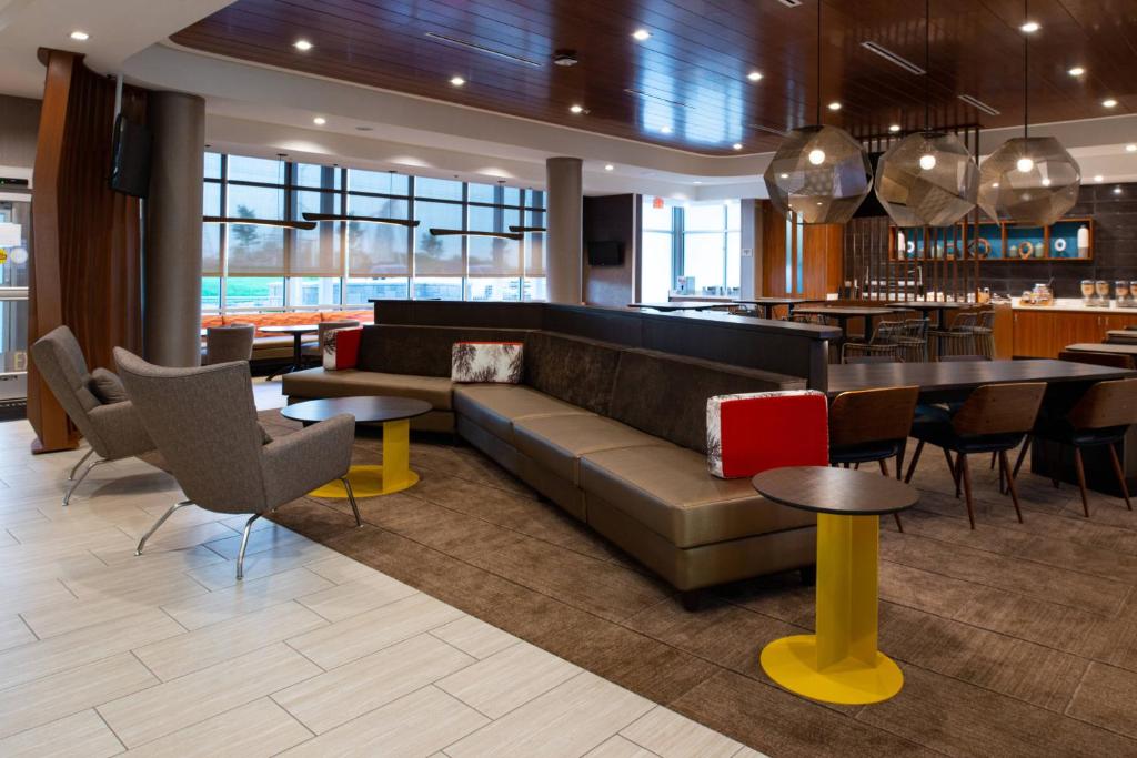 堪萨斯城SpringHill Suites by Marriott Kansas City Northeast的一个带沙发和桌子的大堂和一间酒吧