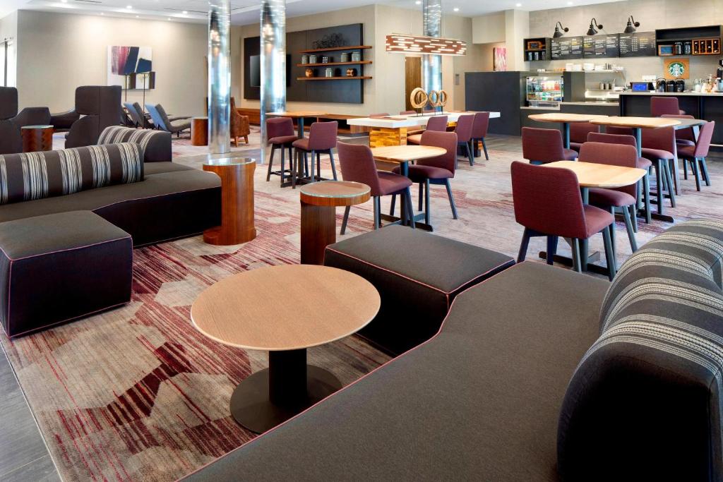 休斯顿休斯顿洲际机场万怡酒店 的一间设有桌椅和桌上电脑的等候室