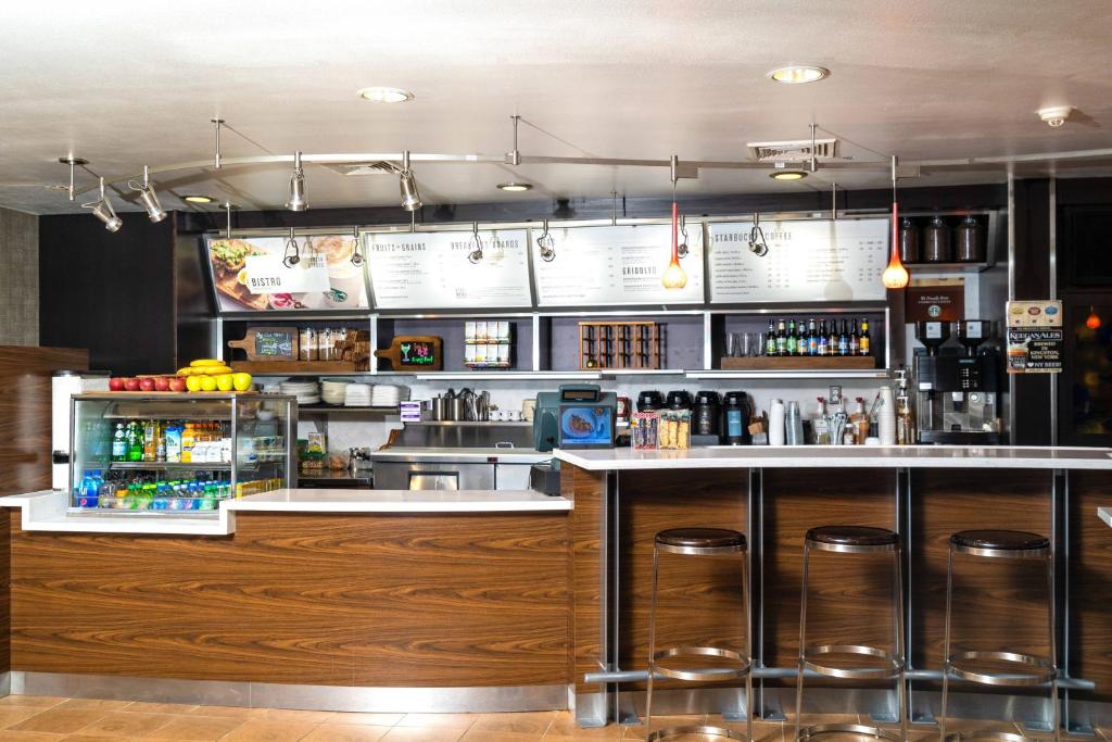 金斯顿金士顿万豪万怡酒店的厨房设有餐厅内带凳子的酒吧