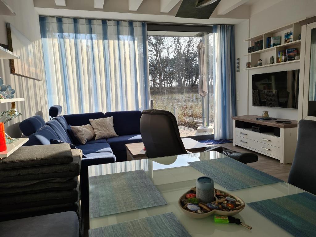 宾茨FeWo Am Meer Prora的客厅配有蓝色的沙发和桌子
