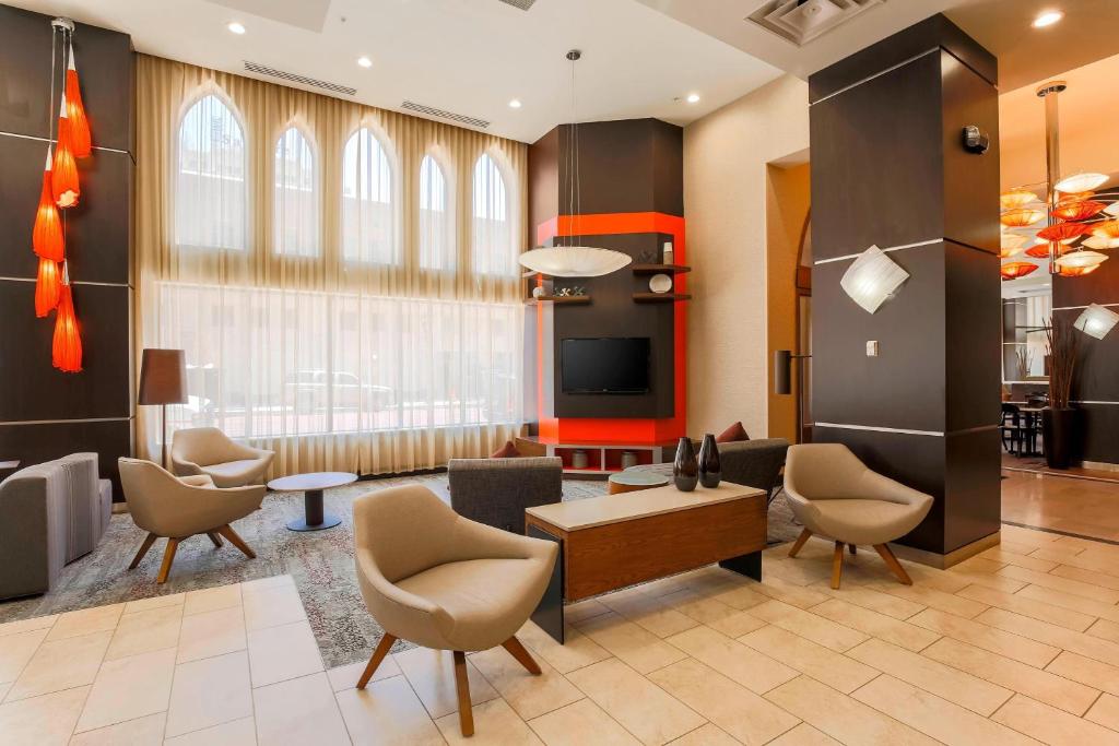 阿马里洛阿马里洛市中心万怡酒店的大堂设有桌椅和大窗户。