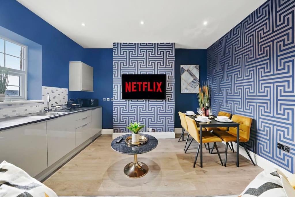 KentPlatinum Grove Modern Flat的一间厨房和带蓝色墙壁及桌子的用餐室