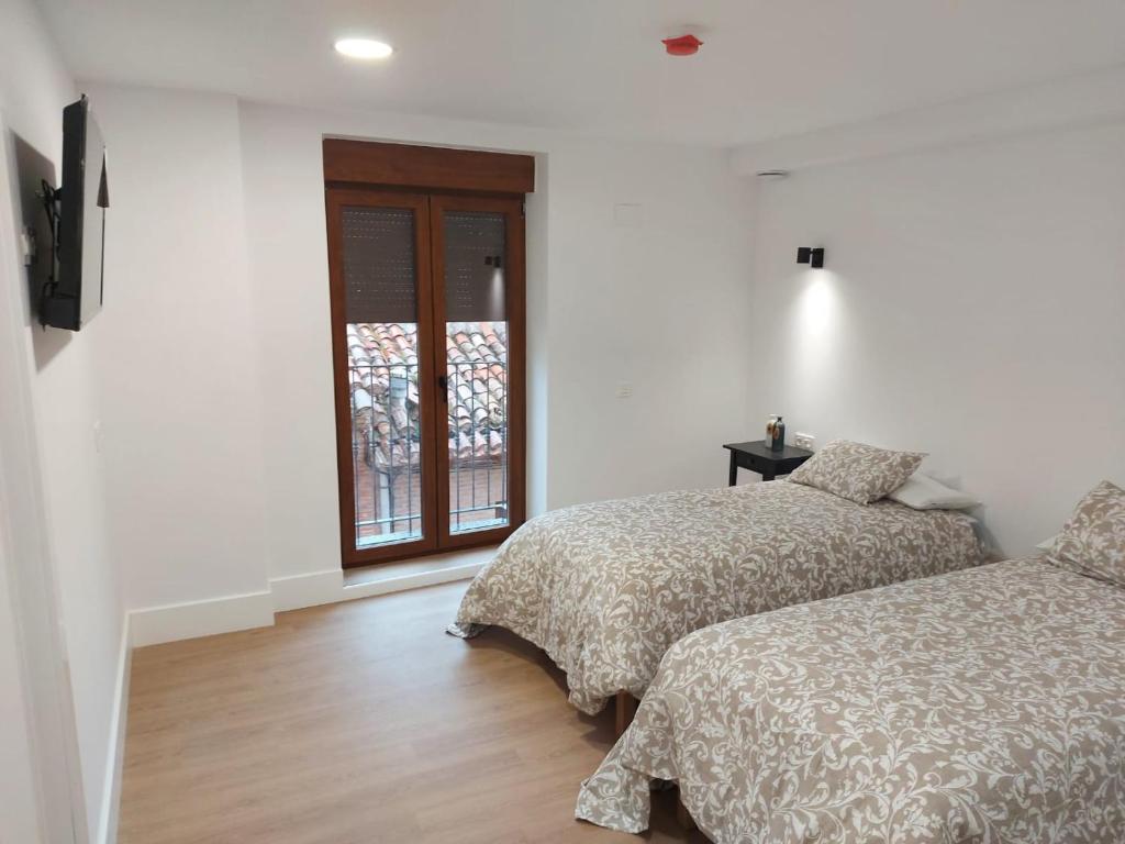 圣多明各德拉Hotel - Hostel Atuvera的一间卧室设有两张床和窗户。