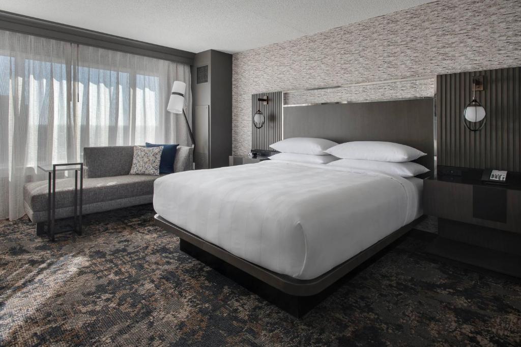 布里奇沃特布里奇沃特万豪酒店的卧室配有一张白色的大床和一张沙发。