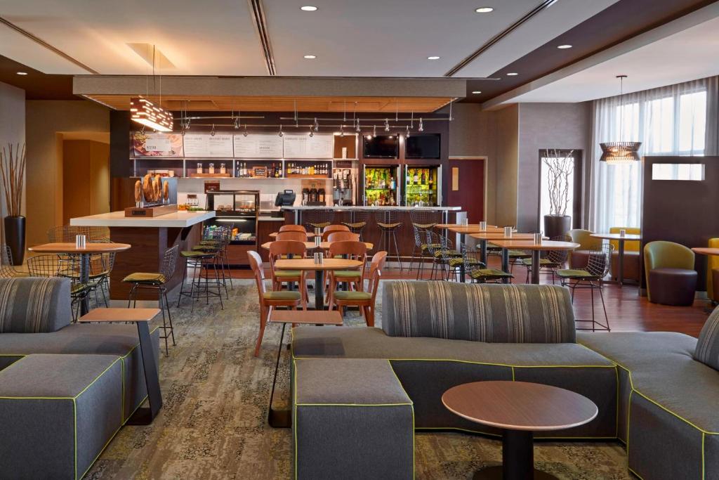 金斯顿金斯顿401公路万怡酒店的一间带桌椅的餐厅和一间酒吧