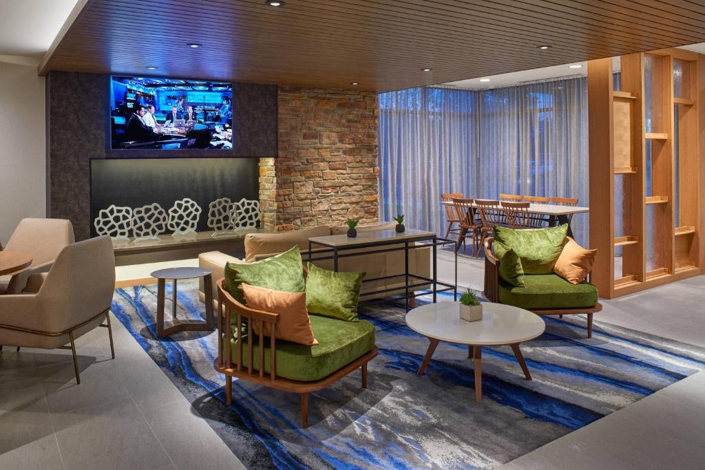 米德兰Fairfield Inn & Suites by Marriott Midland的大堂设有桌椅和电视。