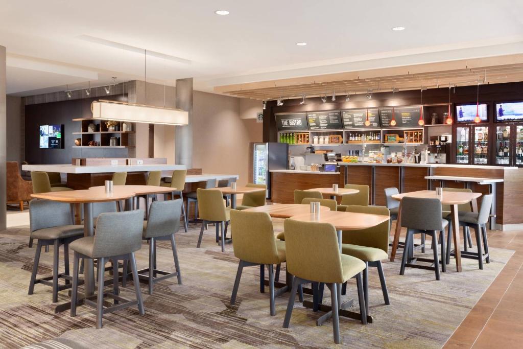 WestwoodCourtyard by Marriott Boston Dedham/Westwood的一间带桌椅的餐厅和一间酒吧