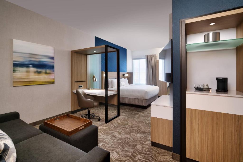 西瓦利城SpringHill Suites By Marriott Salt Lake City West Valley的酒店客房设有一张沙发和一张床