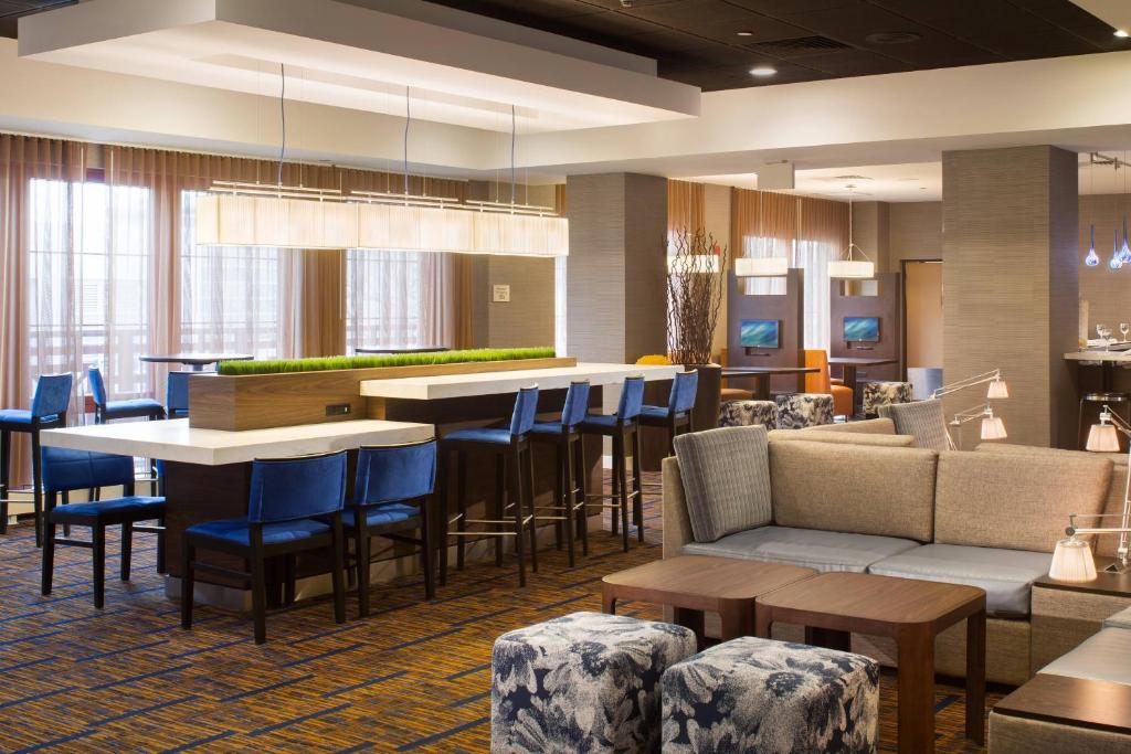 普罗维登斯普罗维登斯市中心万怡酒店的酒店大堂设有酒吧和桌椅
