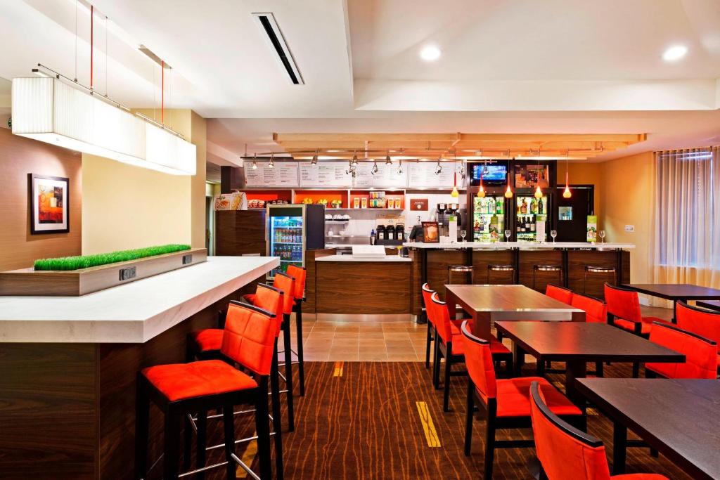 圣安东尼奥圣安东尼奥机场/北极星购物中心万怡酒店的一间带桌椅的餐厅和一间酒吧
