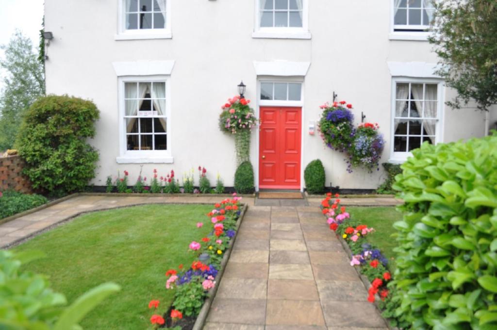 Shardlow霍顿住宿加早餐旅馆的白色的房子,有红色的门和鲜花