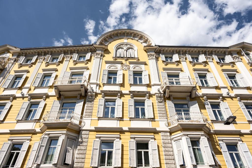 博尔扎诺斯蒂尔格斯卡拉酒店的黄色的建筑,上面有时钟