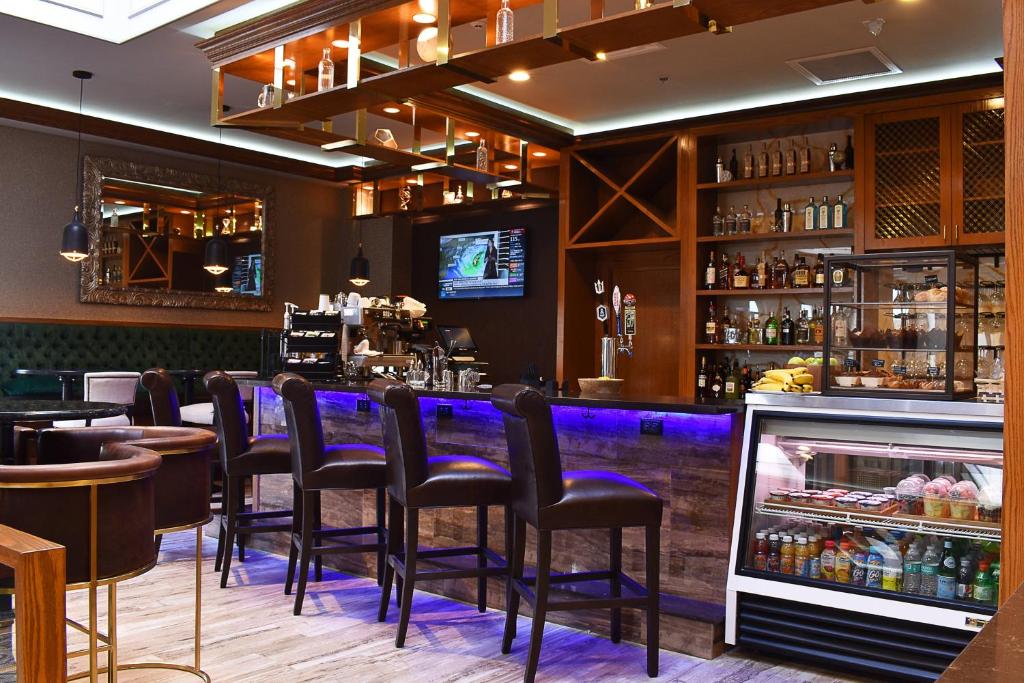 印第安纳波利斯Delta Hotels by Marriott Indianapolis East的餐厅内带黑凳的酒吧