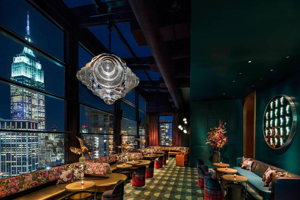 纽约纽约市切尔西慕奇夕酒店的餐厅配有沙发、桌子和吊灯