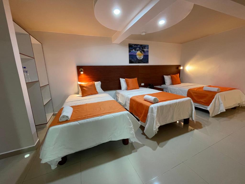 瓜亚基尔Fortune Hotel的一间卧室配有两张带橙色床单的床