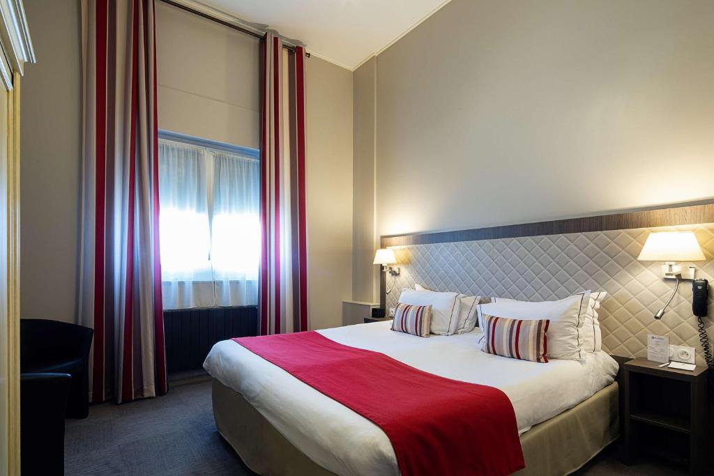 图尔贝斯特韦斯特中央酒店的酒店客房设有一张带红色毯子的大床