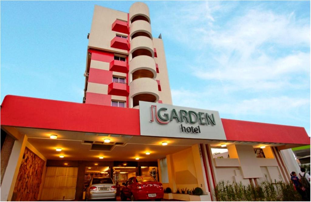 戈亚尼亚Oft Garden hotel的前面有汽车经销商标志的建筑物