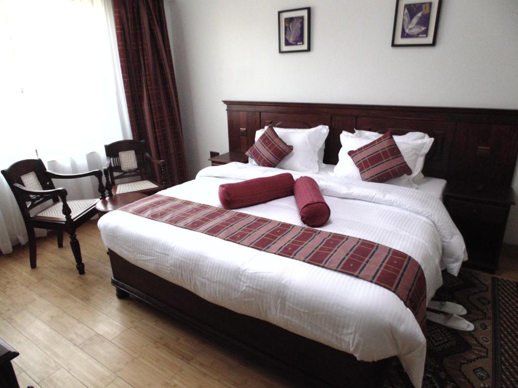 纳库鲁鹰宫酒店 的一间卧室配有一张带红色枕头的大床