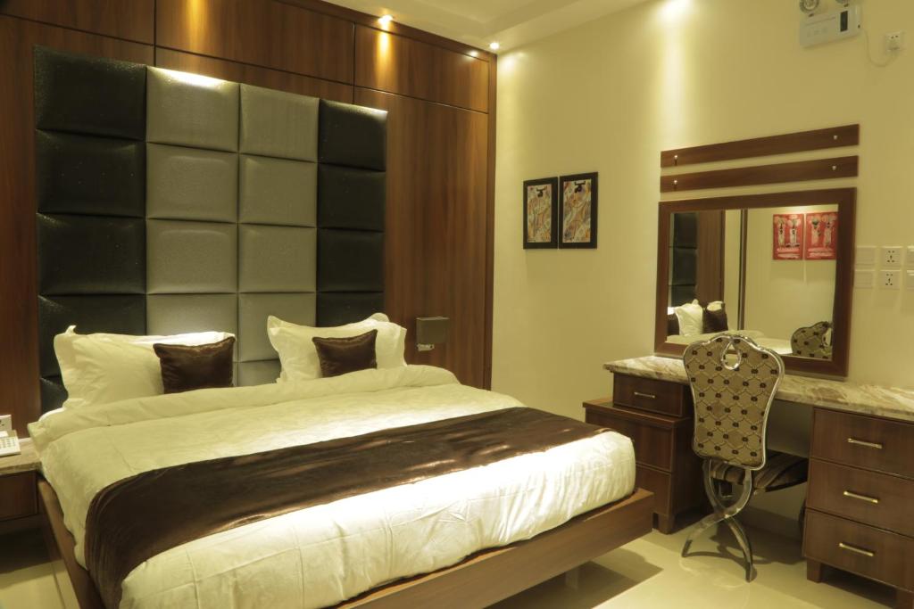 奈季兰Kadi Hotel的一间卧室配有一张床、一张书桌和一面镜子