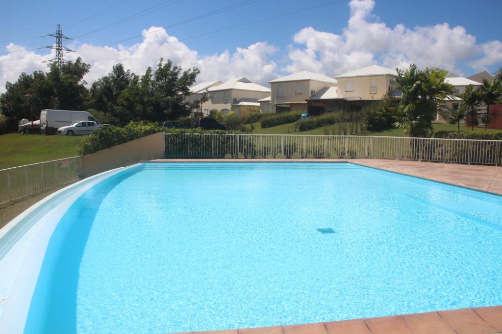 拜马欧les Aliceas appartement cosy的一座大型蓝色游泳池,其背景是房屋
