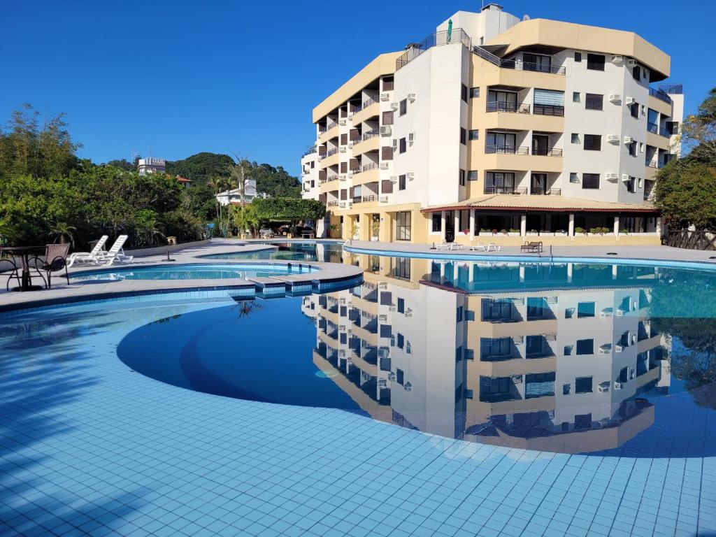 弗洛里亚诺波利斯Merit Plaza - Pe na Areia的酒店游泳池的背景是一座建筑