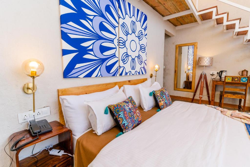 穆克缇斯瓦SHIVAYA since 1953的卧室配有一张挂着蓝白色画作的床铺。