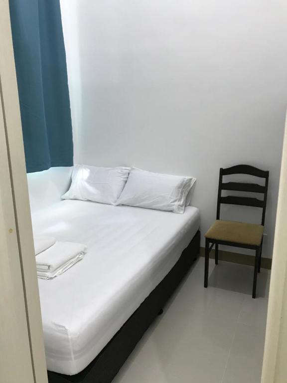 马尼拉South Residences staycation的房间里的一张床和椅子