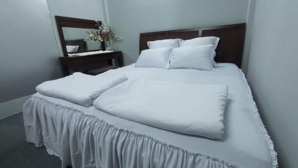 芹苴Enjoy Mekong Hostel的一张配有白色床单和枕头的大床