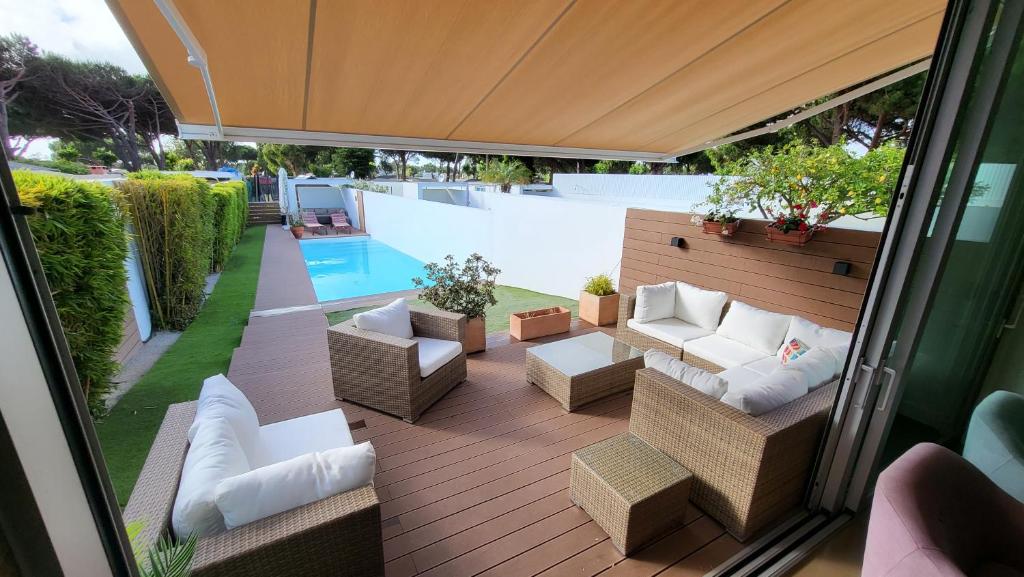 艾迪亚梅科卡萨帕海滨度假屋的一个带沙发和椅子的户外庭院和一个游泳池