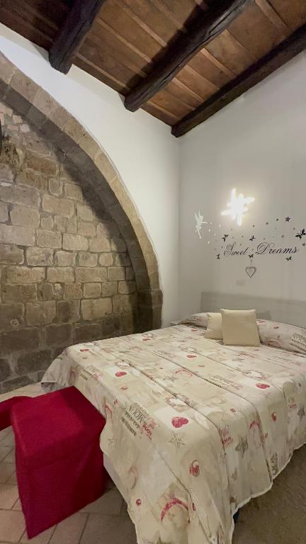 维泰博Casa medievale Il Rifugio di Olimpia的卧室配有砖墙内的床铺