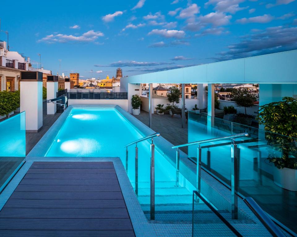 塞维利亚nQn Aparts & Suites Sevilla的建筑物屋顶上的游泳池