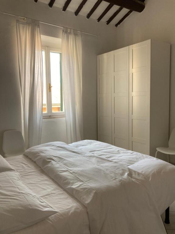 马西亚娜马里纳La casina的卧室配有白色的床和窗户。